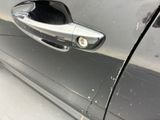 a close up of a car door handle with a cat sticking out of it