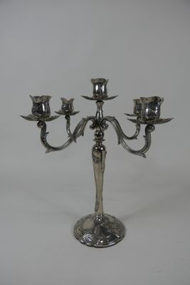 une image représentant un chandelier en argent sur lequel sont posées trois bougies