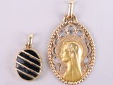 two gold and black pendants of a woman and a man