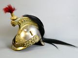 un casque doré orné d'une plume rouge