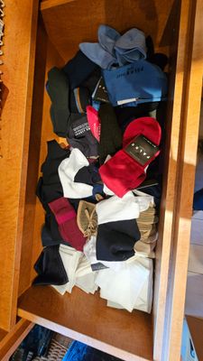 une armoire en bois remplie d'une multitude de vêtements et de chaussures