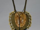 a necklace with beads on a stand on a white background