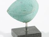 sculpture représentant un oiseau posé sur un socle, sur fond blanc