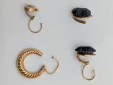 three pairs of gold earrings and a ring with a black stone