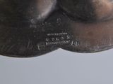 a silver plate with a picture of a man ' s face on it