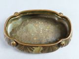 a close up of a green and gold bowl on a white surface