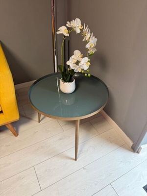 a small table with flowers on it in the corner of a room