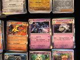 a lot of different pokemon cards on the table