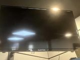 a flat screen tv hanging from the ceiling in a room