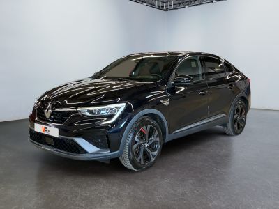 a black car is parked in a large room with a white wall