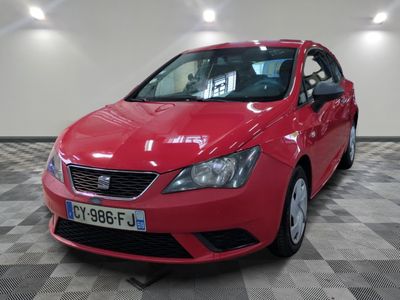 la voiture rouge est garée sur le sol en damier du garage