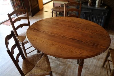 une table en bois entourée de chaises dans un salon