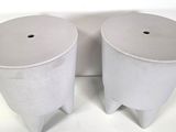 two white trash cans sitting next to each other on a white surface