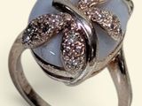 silver ring with blue stone and brown diamonds on it