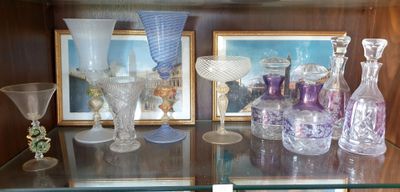 de nombreux vases en verre posés sur une étagère en verre dans une vitrine