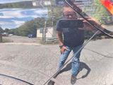 a man taking a picture of himself in the reflection of a car window