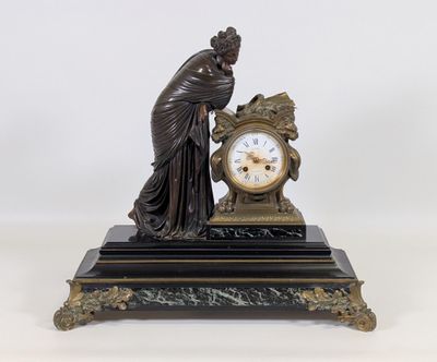 une statue de femme tenant une horloge sur une table