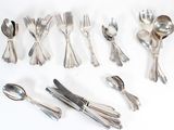 a lot of spoons and forks laid out on the table