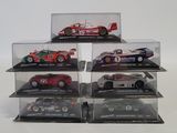 six model cars in a display case on a white surface