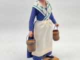 figurine of a woman in a blue dress holding two buckets