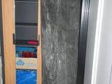 un sac noir posé par terre à côté d'une porte
