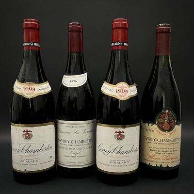 quatre bouteilles de vin sont alignées sur une surface noire