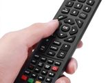 someone is holding a remote control in their hand on a white background