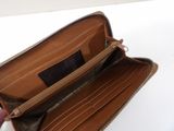 someone is holding a brown wallet with a black label on it