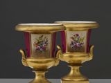 une paire de vases en or ornés de fleurs, posés sur une table