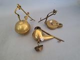 three brass teapots and a tea kettle on a white surface