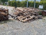 a pile of wood on the ground next to a fence