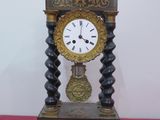 une horloge posée sur une table recouverte d'une nappe rose