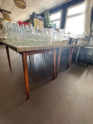 une longue table sur laquelle sont posés de nombreux verres, dans une pièce