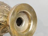 a gold vase that is sitting on a white surface