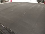 a black car parked in a parking lot next to other cars