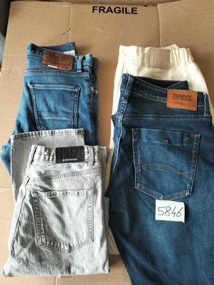 two pairs of men ' s jeans sitting on top of a cardboard box