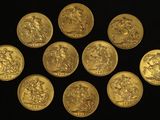 six gold sovereigns are arranged in a circle on a black surface