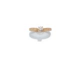 une bague en or sertie d'un diamant sur fond blanc