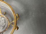 a gold clock with a glass case on it