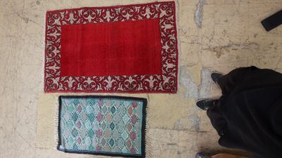 three rugs on the floor next to a pair of shoes