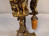 brass figurines of lions on a pedestal with a cork stopper