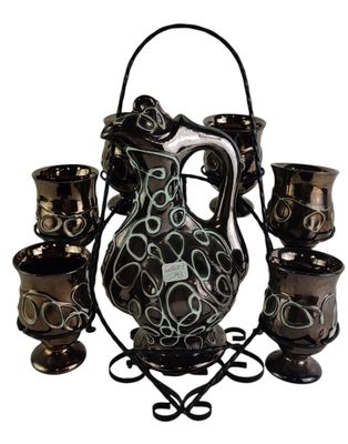 a black and white pitcher and cups on a stand