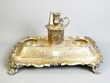 a silver tray with a silver pitcher on top of it