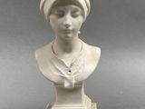 white marble bust of a woman with a turban on her head