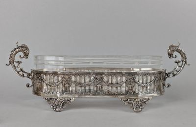 a large silverplated bowl with ornate design and handles