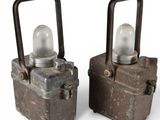 two small metal containers with lights on them on a white surface