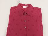 Le t-shirt est rouge et est orné d'un motif en forme de cœur.