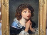 portrait d'une jeune fille en robe bleue, les mains jointes devant le visage
