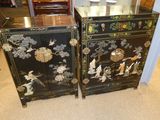 two black and gold painted cabinets with flowers and birds on them