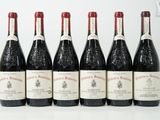 six bouteilles de vin sont alignées sur une surface blanche